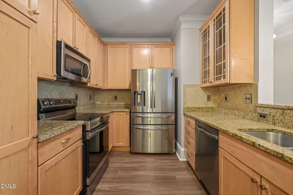 a kitchen with stainless steel appliances granite countertop a refrigerator stove and sink