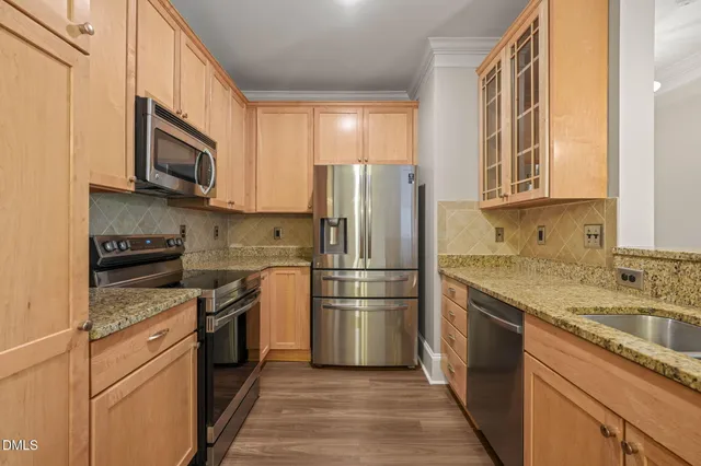 a kitchen with stainless steel appliances granite countertop a refrigerator stove and sink