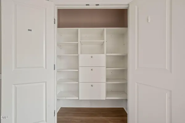a view of walk in closet with empty racks