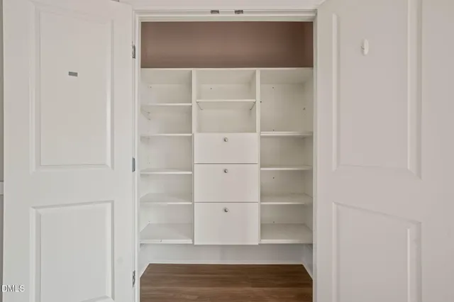 a view of walk in closet with empty racks