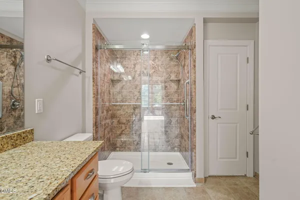 a bathroom with a granite countertop sink toilet and shower