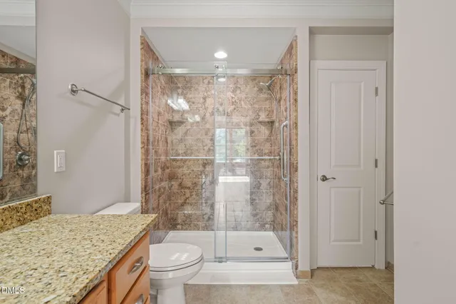 a bathroom with a granite countertop sink toilet and shower