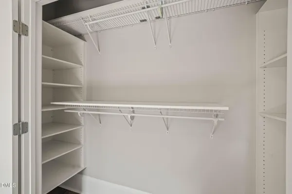 a view of walk in closet with empty racks