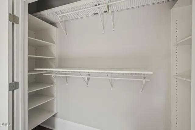 a view of walk in closet with empty racks