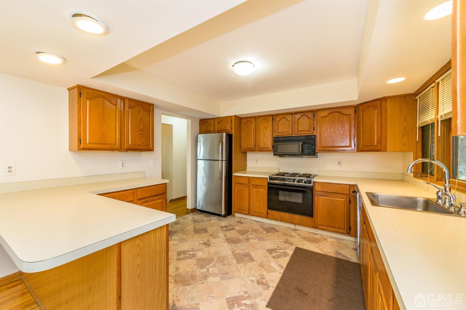 58 Forest Road Andover, NJ 07821 - Photo 12 of 34 a kitchen with stainless steel appliances granite countertop a sink stove and refrigerator