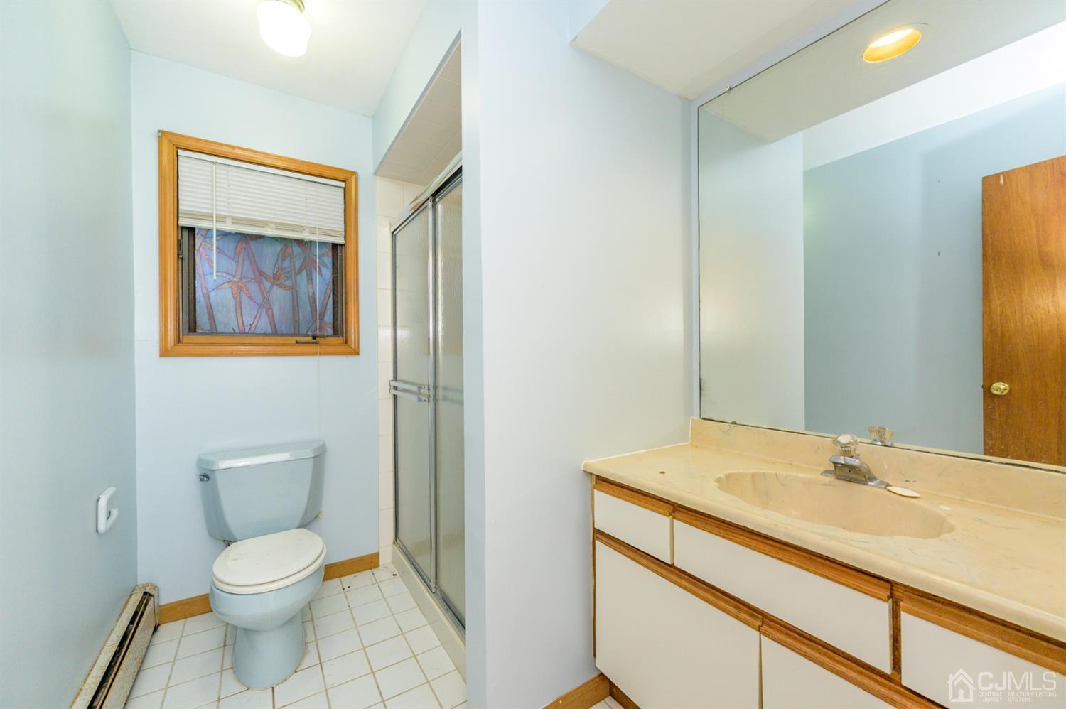 58 Forest Road Andover, NJ 07821 - Photo 8 of 34 a bathroom with a toilet sink and mirror