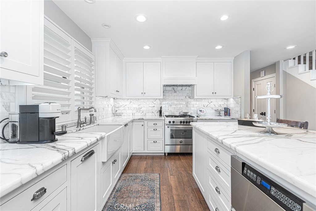 213 34th Street Newport Beach, CA 92663 - Photo 23 of 32 a kitchen with a sink a stove top oven and white cabinets