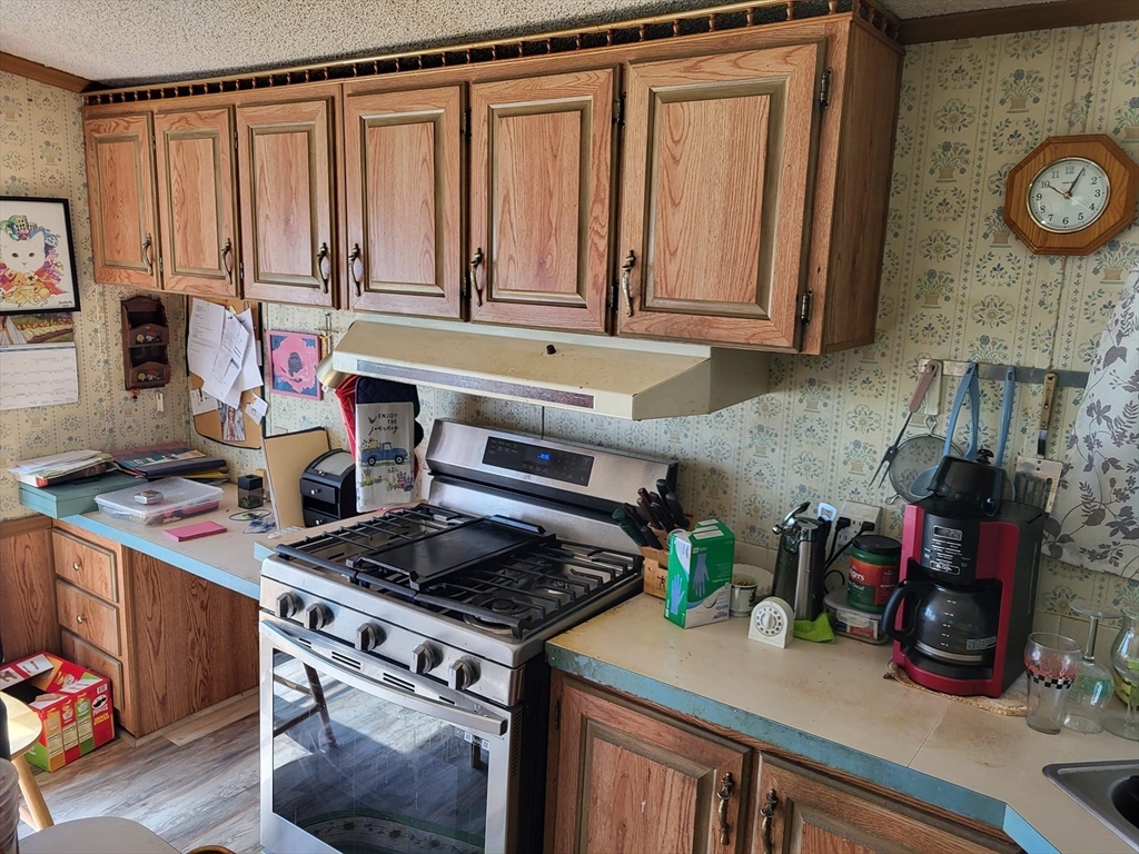 74 Old Turnpike Road Thompson, CT 06262 - Photo 4 of 18 a kitchen with a stove and a wooden cabinets