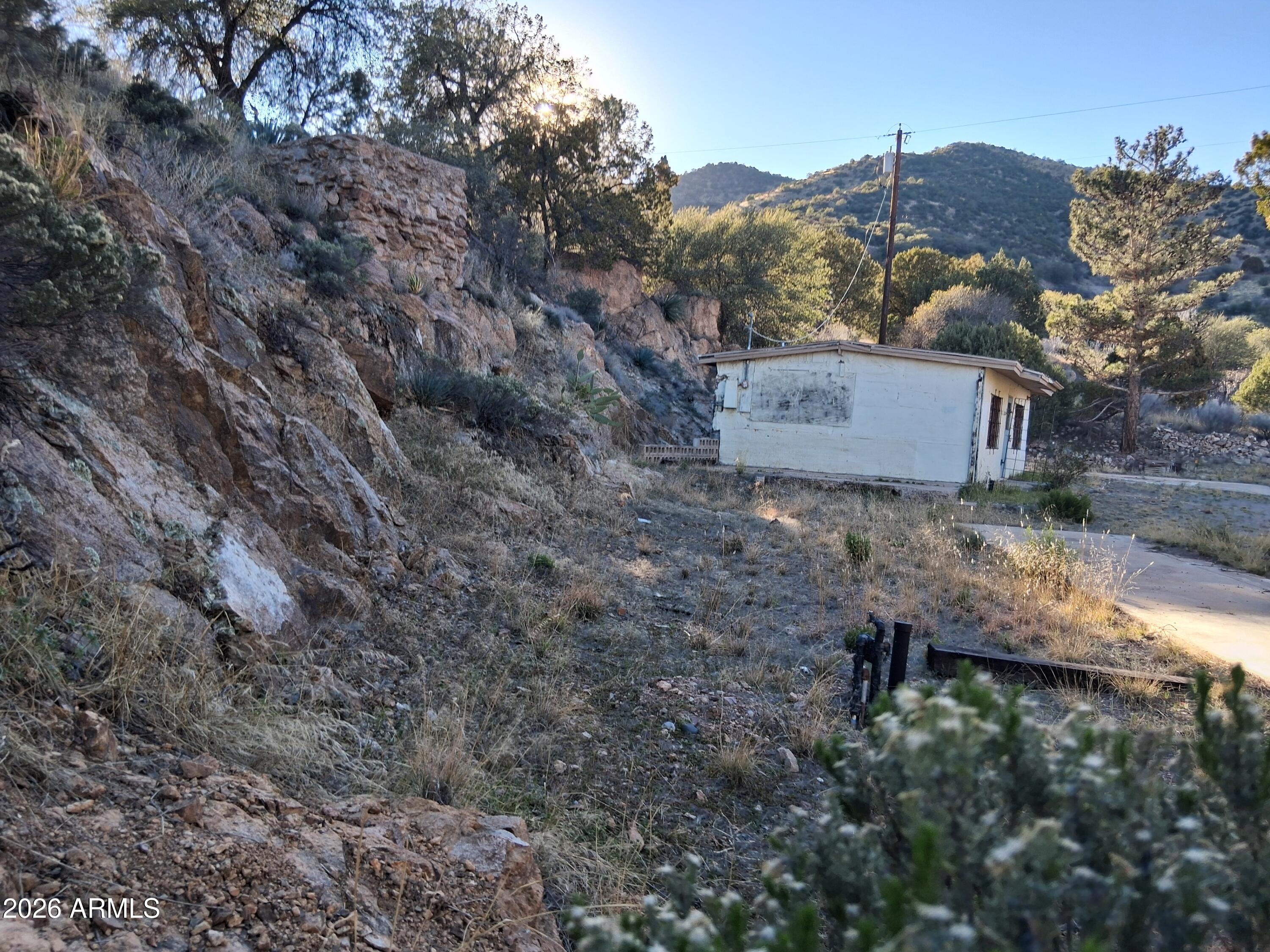 1589 Highway 80 Bisbee, AZ 85603 - Photo 3 of 18 a view of a wooden house with a yard