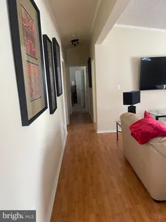 a hallway with a couch and a flat screen tv