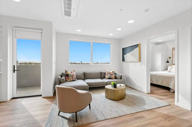 a bedroom with a white bed and a painting on the wall