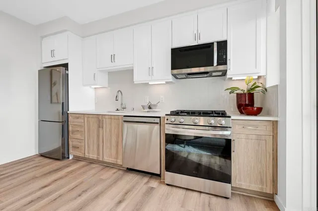 a view of kitchen with wooden floor and electronic appliances