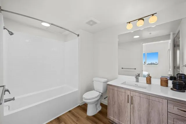 a view of an empty room with wooden floor and entryway