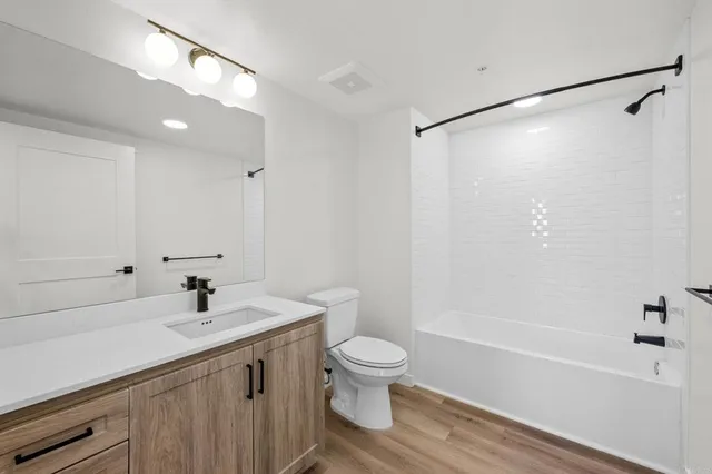 a view of an empty room with wooden floor and closet