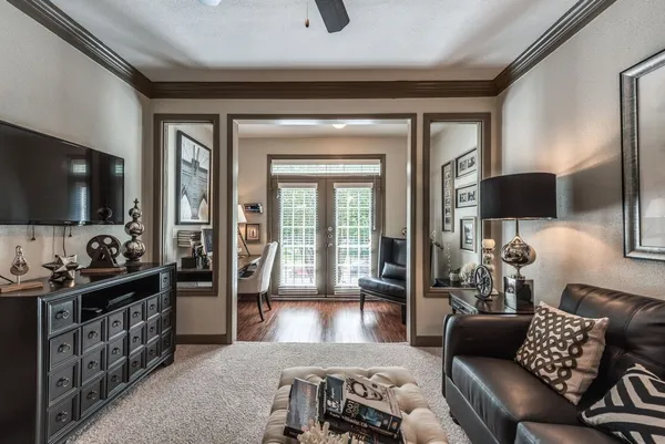 a living room with furniture a flat screen tv and large window
