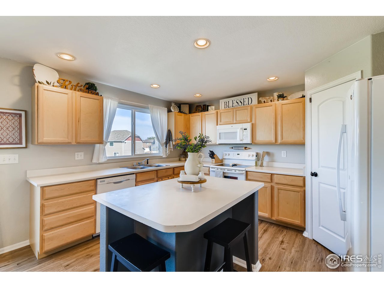 7501 21st Street Greeley, CO 80634 - Photo 13 of 27 a kitchen with a sink refrigerator and cabinets
