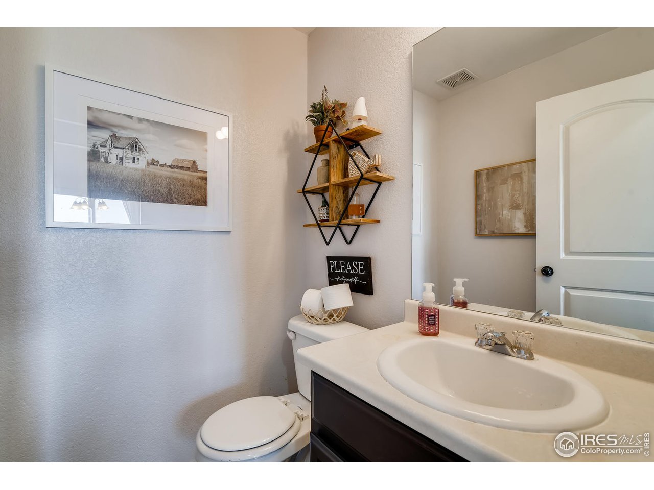 7501 21st Street Greeley, CO 80634 - Photo 16 of 27 a bathroom with a sink mirror and toilet