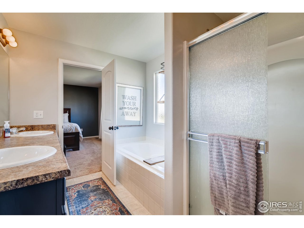 7501 21st Street Greeley, CO 80634 - Photo 21 of 27 a bathroom with a sink a mirror and a bathtub