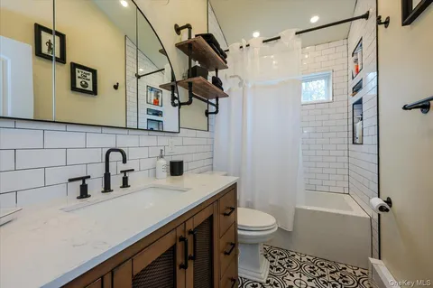 a bathroom with a sink a toilet a mirror and shower