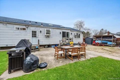 a view of a backyard with furniture porch and a grill