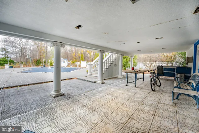 a patio with table and chairs and potted plants