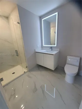 a bathroom with a granite countertop sink a toilet and shower