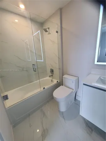 a bathroom with a granite countertop sink a toilet and shower