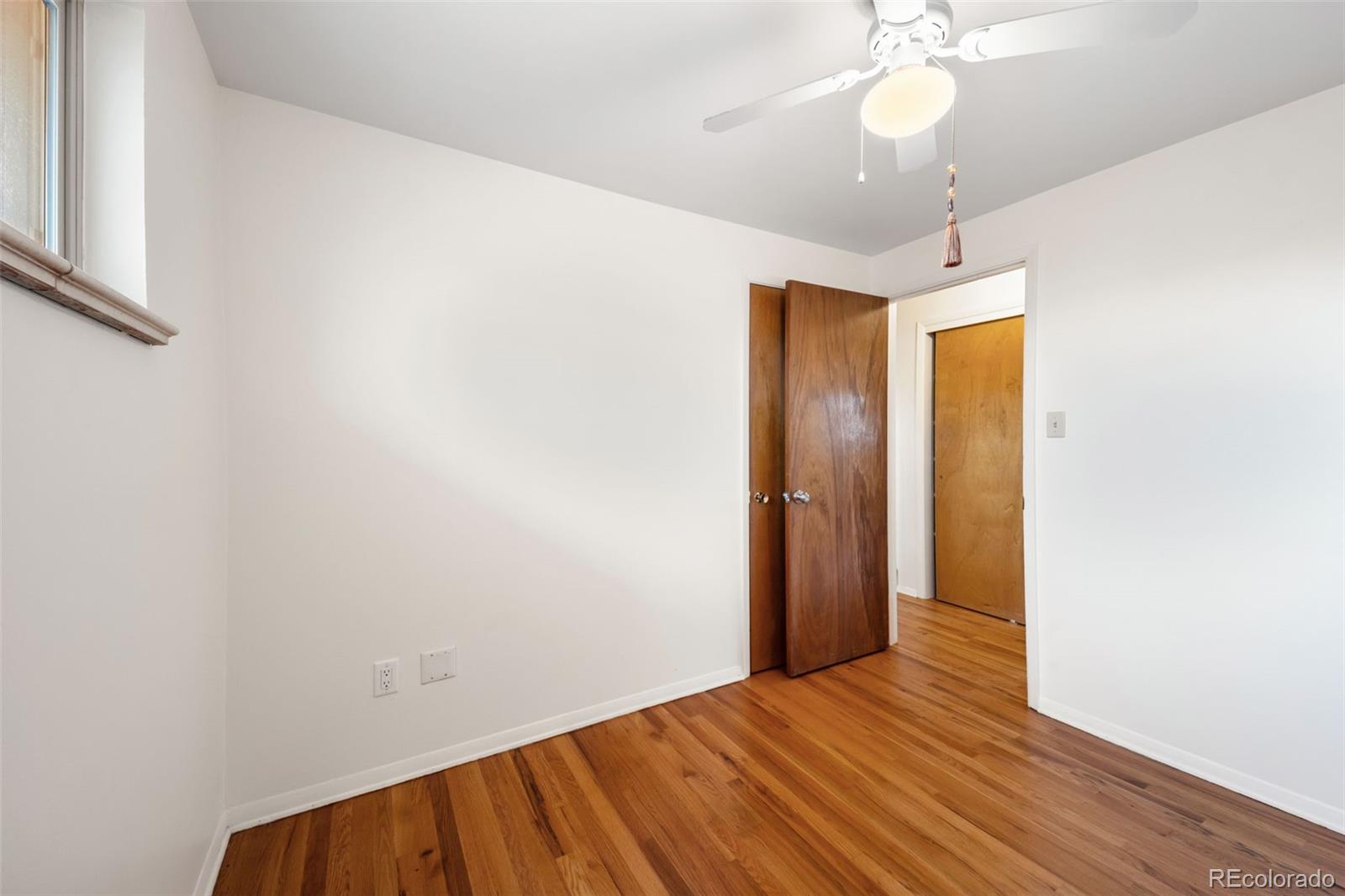4744 Dudley Street Wheat Ridge, CO 80033 - Photo 14 of 16 an empty room with wooden floor fan and windows