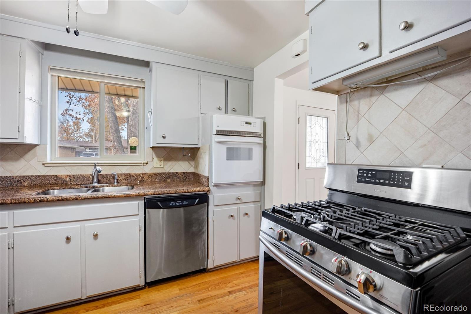 4744 Dudley Street Wheat Ridge, CO 80033 - Photo 5 of 16 a kitchen with stainless steel appliances a stove a sink and a microwave