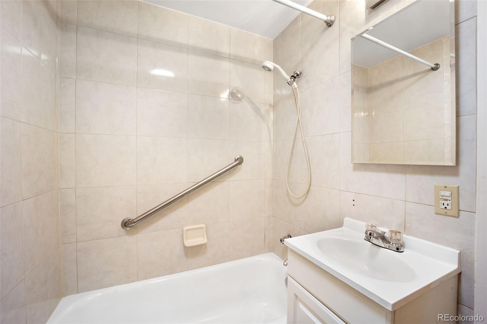 4744 Dudley Street Wheat Ridge, CO 80033 - Photo 10 of 16 a bathroom with a sink a vanity and shower