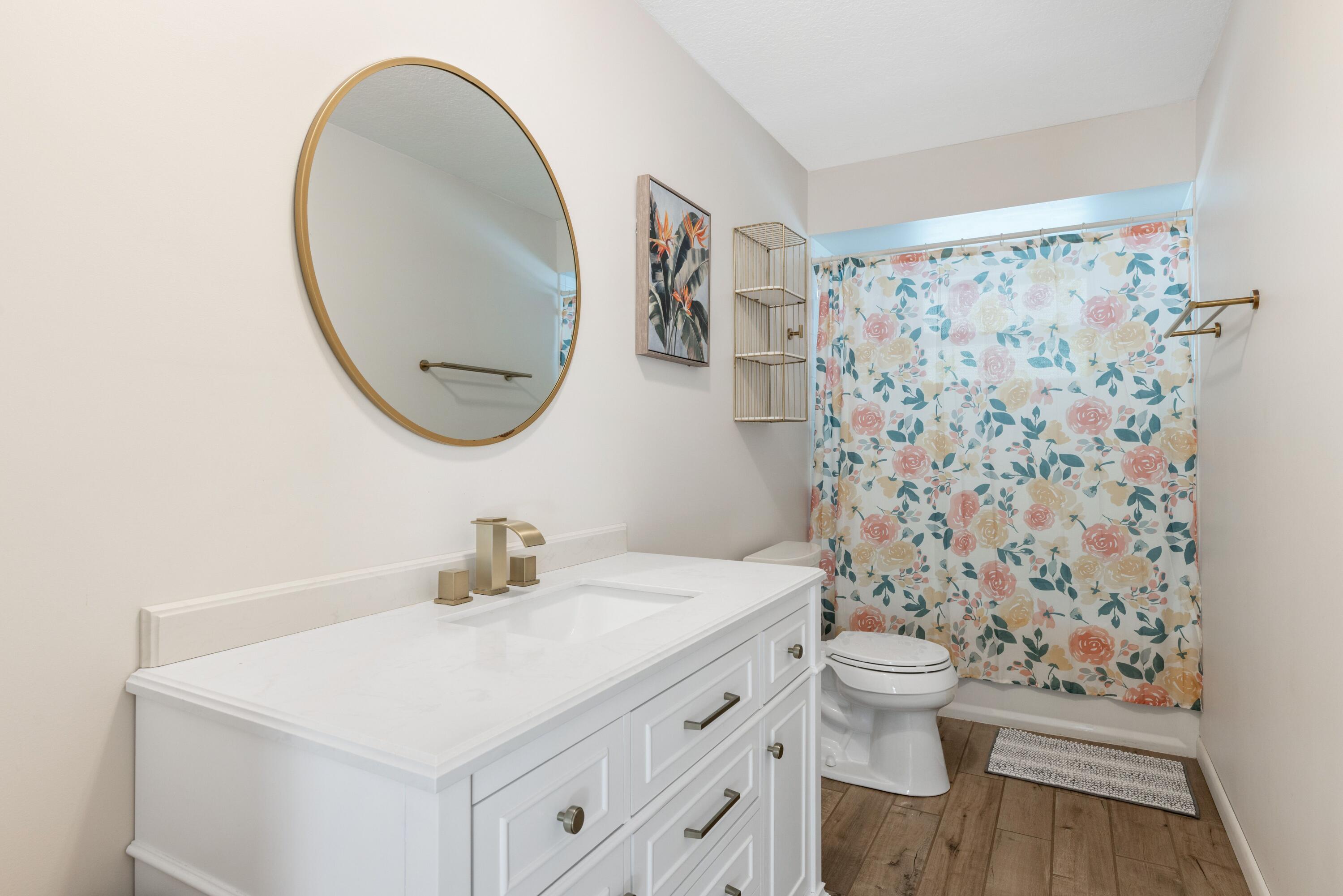 1104 Northwest 12th Terrace Stuart, FL 34994 - Photo 13 of 32 a bathroom with a sink a toilet and a mirror
