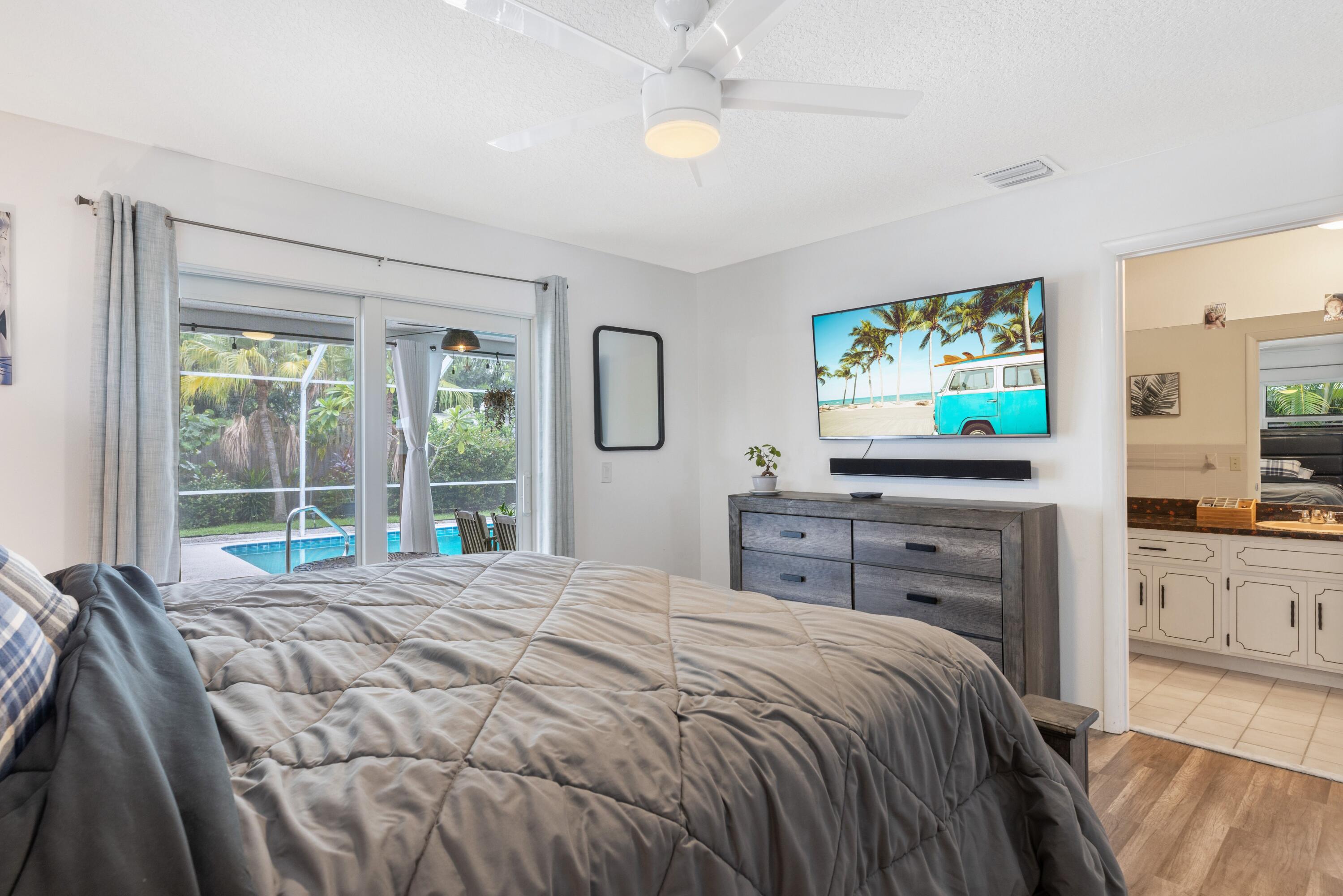 1104 Northwest 12th Terrace Stuart, FL 34994 - Photo 16 of 32 a bedroom with a bed and a flat screen tv