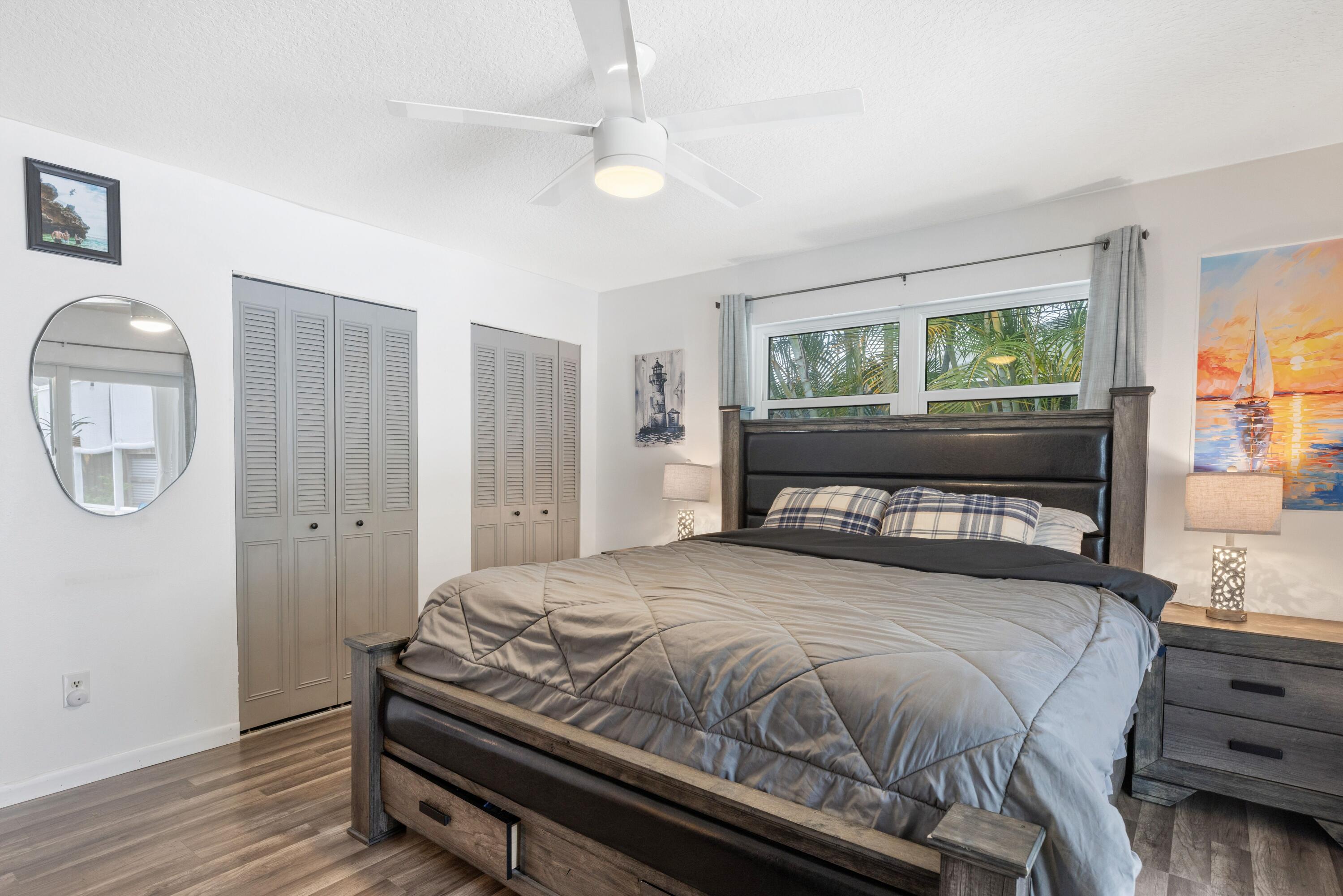 1104 Northwest 12th Terrace Stuart, FL 34994 - Photo 17 of 32 a bedroom with a bed mirror and window
