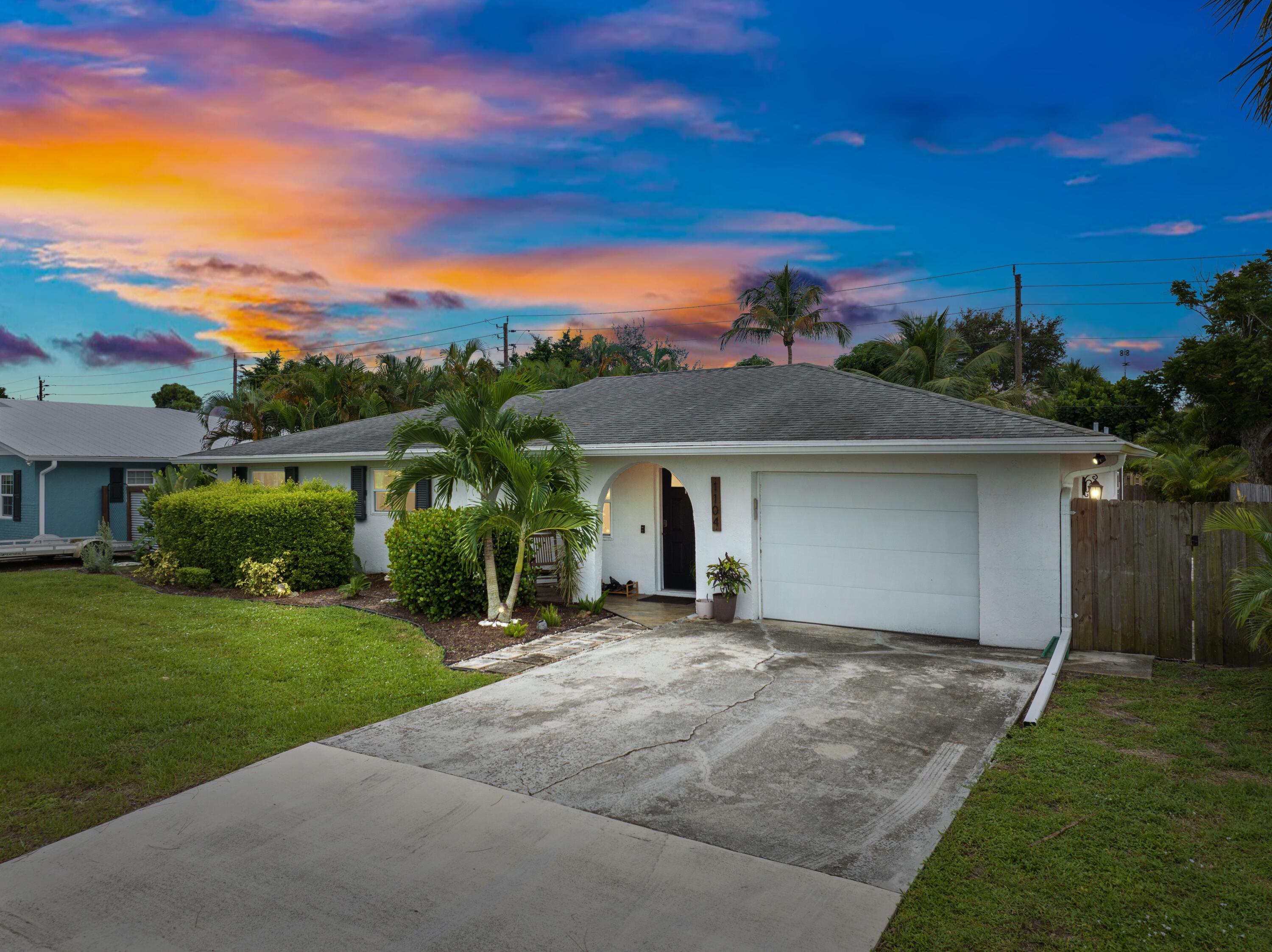 1104 Northwest 12th Terrace Stuart, FL 34994 - Photo 4 of 32 a front view of a house with a yard and garage
