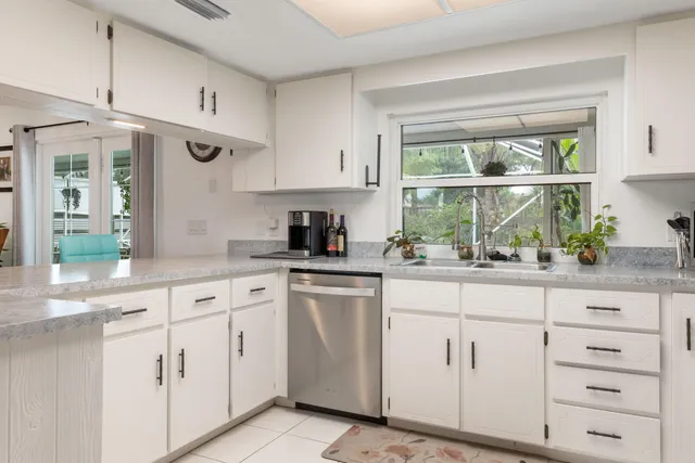 a kitchen with white cabinets and white stainless steel appliances