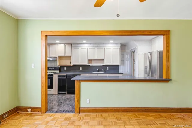 a view of a kitchen with kitchen island a sink wooden floor and a counter top space