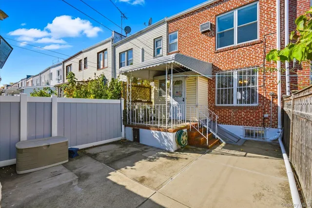 a view of a house with a small yard and wooden fence