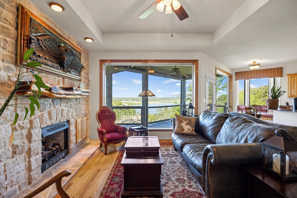 515 Coventry Road Spicewood, TX 78669 - Photo 12 of 36 a living room with furniture a flat screen tv and a fireplace