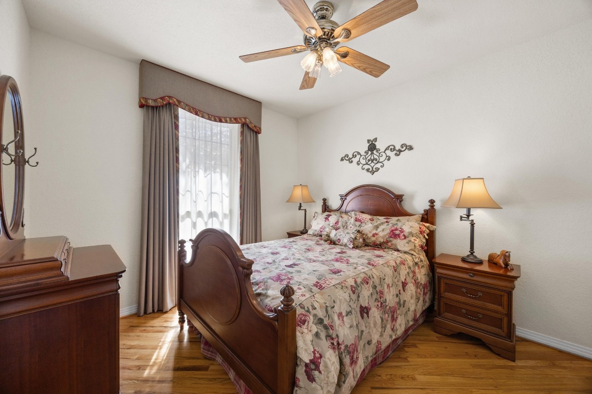 515 Coventry Road Spicewood, TX 78669 - Photo 23 of 36 a bedroom with a bed and a chandelier