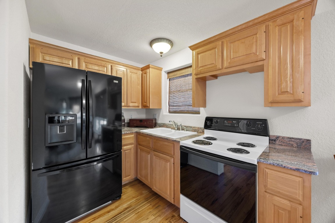 515 Coventry Road Spicewood, TX 78669 - Photo 27 of 36 a kitchen with a refrigerator sink and cabinets