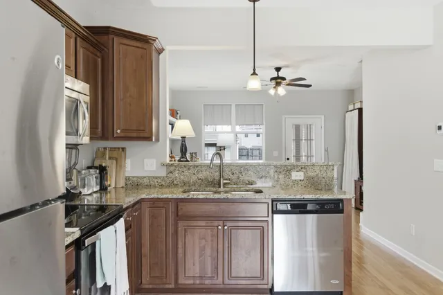 a kitchen with stainless steel appliances granite countertop a sink a stove and cabinets