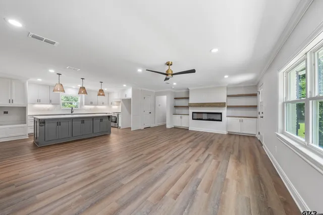 a large kitchen with a lot of cabinets and wooden floor