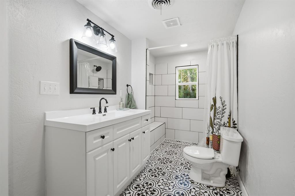 3325 Dove Creek Road Cleburne, TX 76031 - Photo 15 of 40 Bathroom featuring a white vanity with black hardware, a rectangular mirror, and a three-light fixture