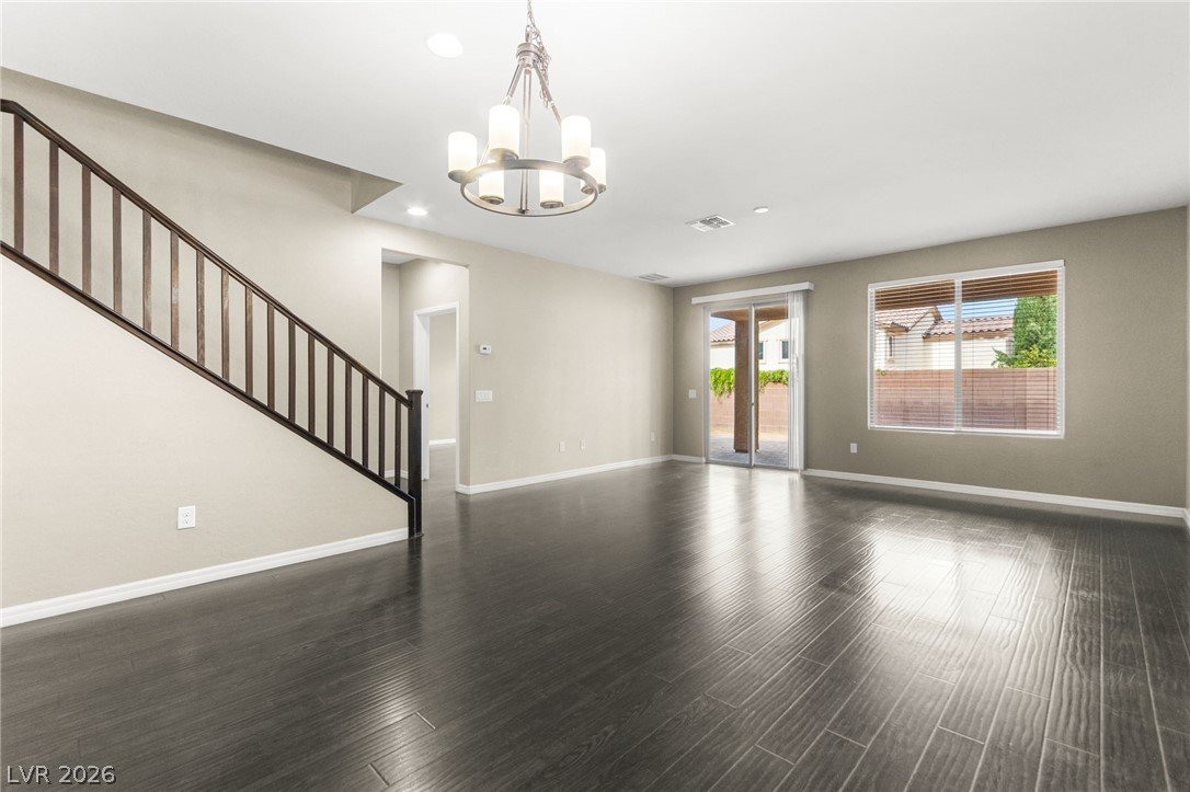 11048 Prairie Grove Road Las Vegas, NV 89179 - Photo 16 of 75 A spacious living area with sleek wood flooring and ample natural light, ideal for entertaining.