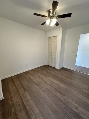 a view of a livingroom with wooden floor and a ceiling fan