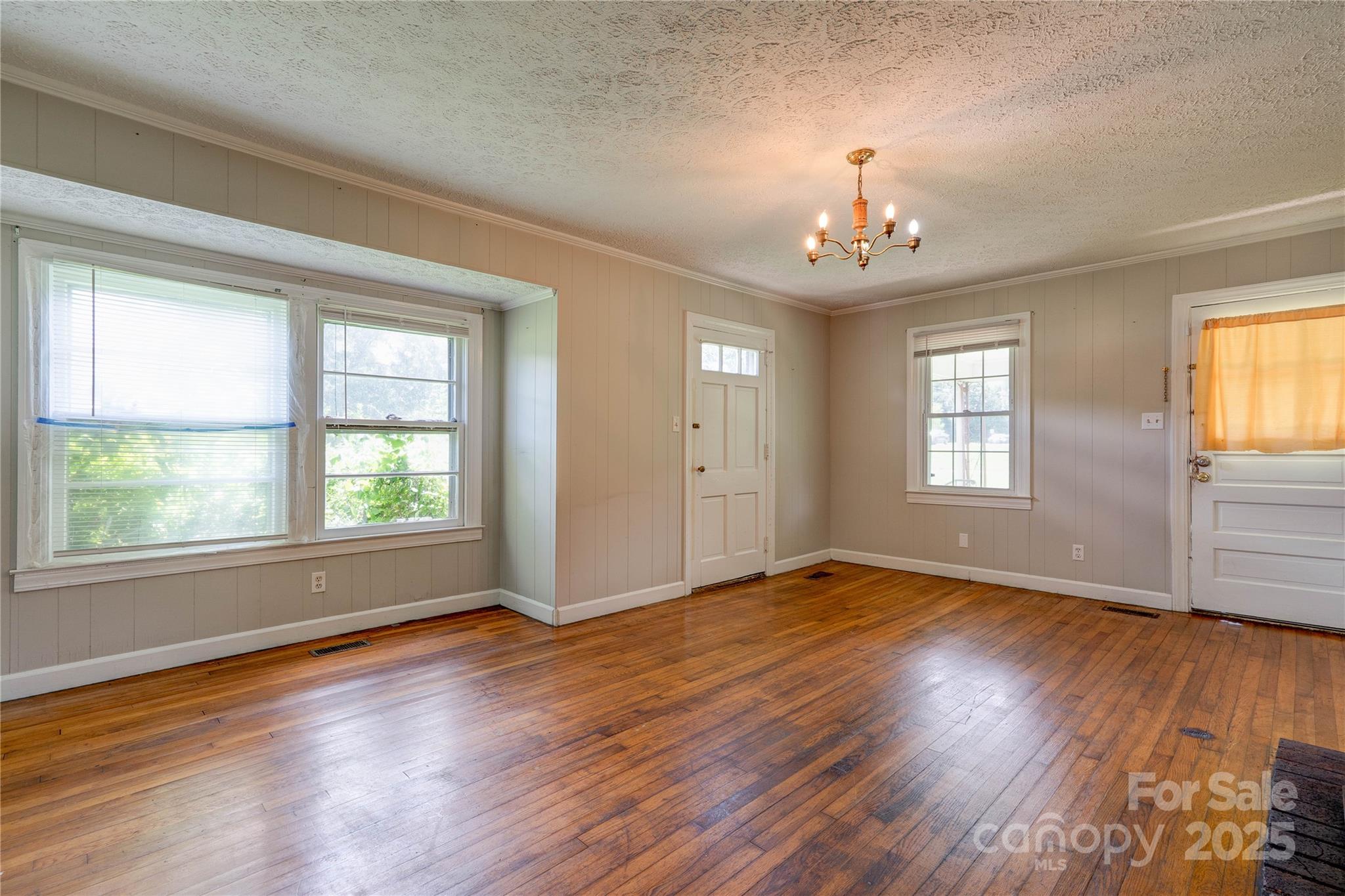 1414 South Post Road Shelby, NC 28152 - Photo 8 of 24 an empty room with wooden floor chandelier and windows