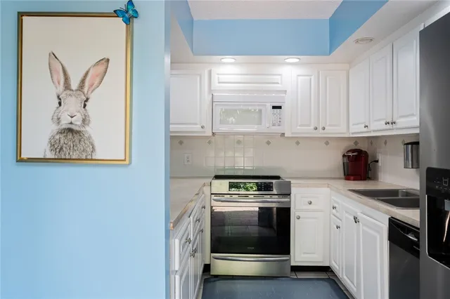 a kitchen with stainless steel appliances granite countertop a stove a sink and a microwave