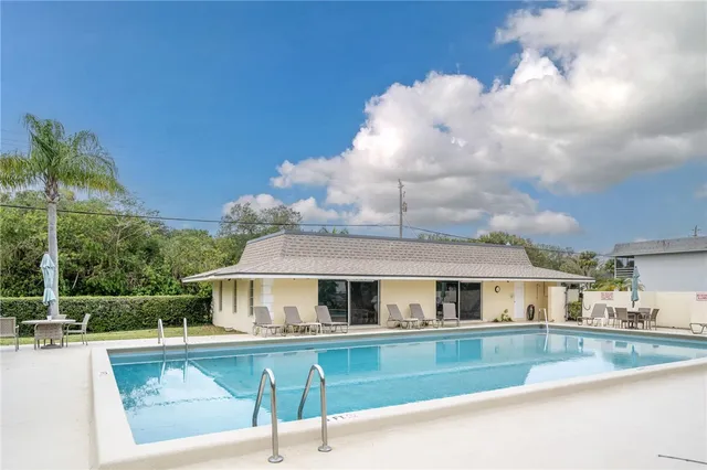 a view of a house with swimming pool and sitting area