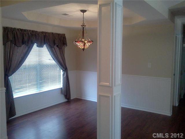 122 Elrosa Road Mooresville, NC 28115 - Photo 3 of 16 an empty room with wooden floor fan and windows