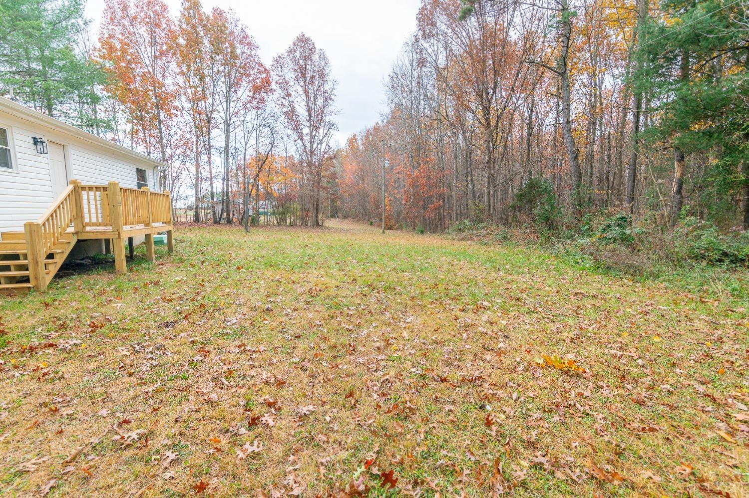 419 Robinson Road Appomattox, VA 24522 - Photo 18 of 19 a backyard of a house with lawn chairs and wooden fence